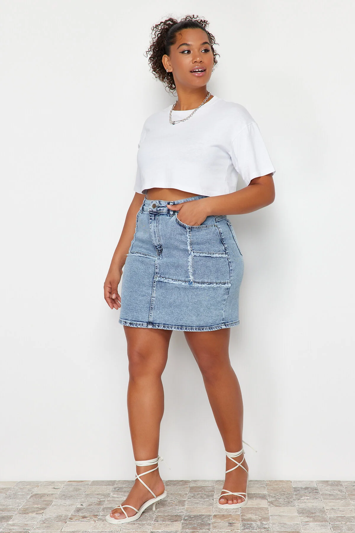 Trendyol Curve  Hellblauer Mini-Jeansrock mit Ziernähten und Quasten TBSSS24AZ00018