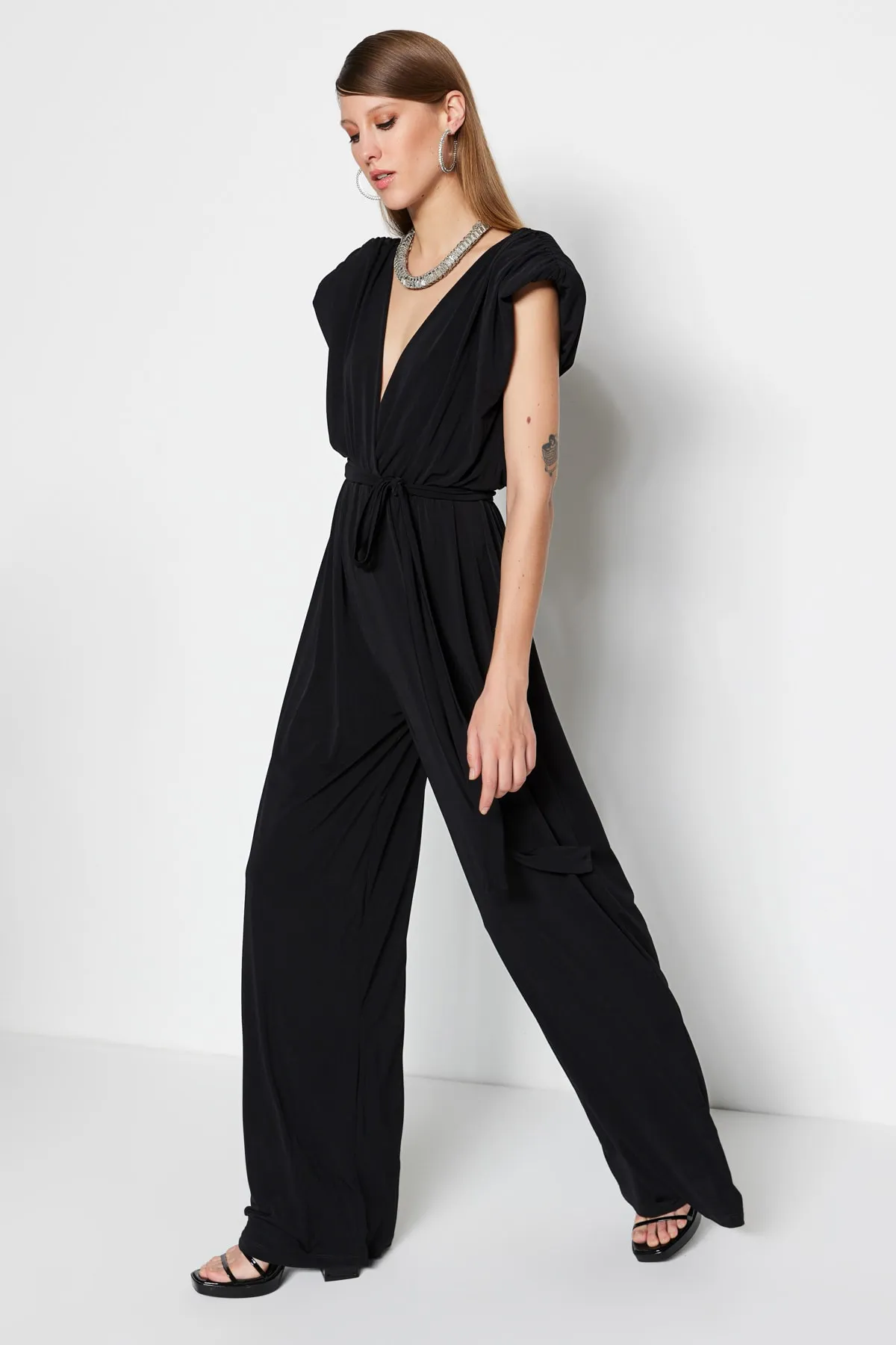 Trendyol Collection  Schwarzer Strick-Jumpsuit mit V-Ausschnitt und Gürtel TPRSS23TU00029