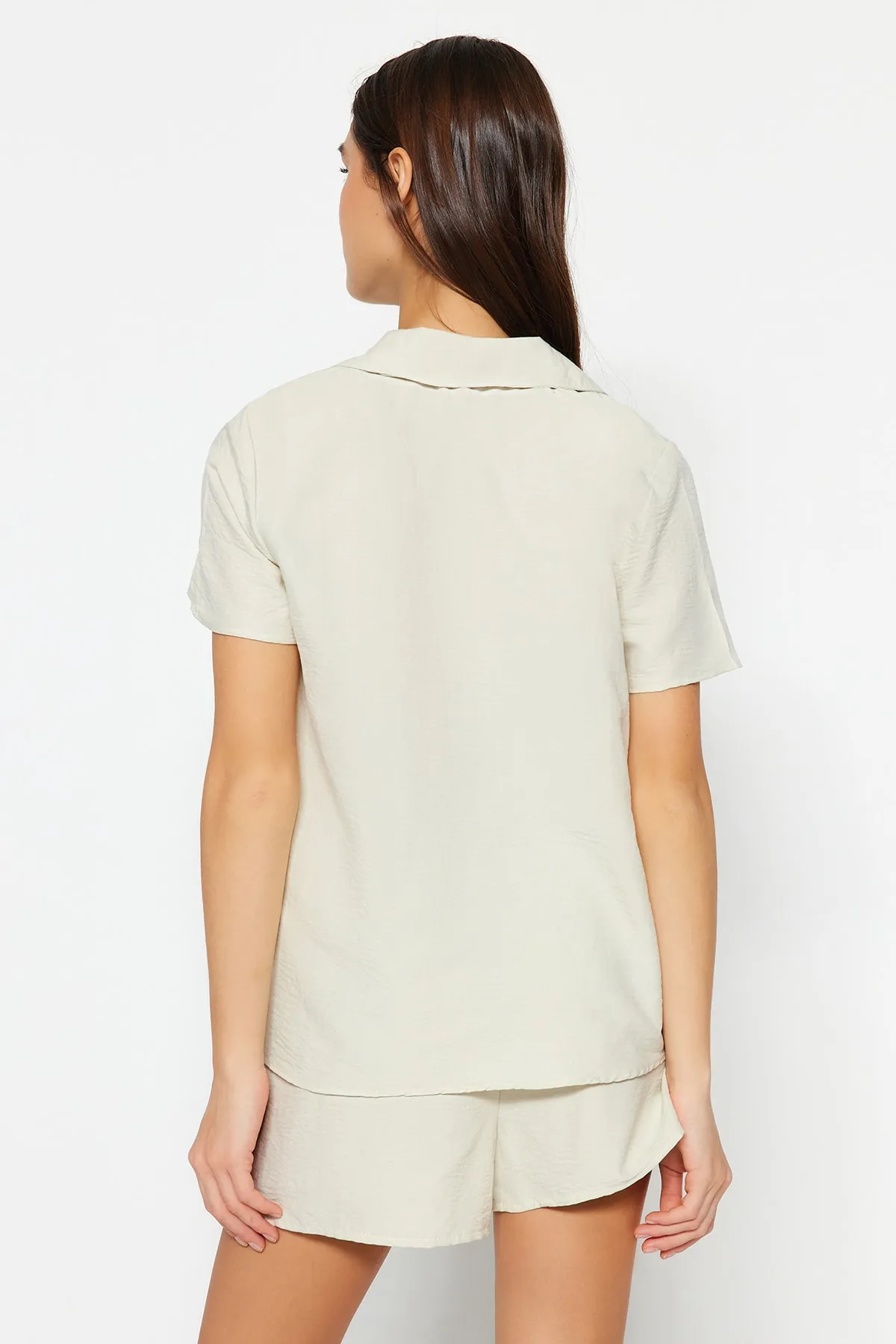 Trendyol Collection  Hellbeigefarbenes Pyjama-Set aus Hemd und Shorts mit aufgesticktem Slogan THMSS23PT00232