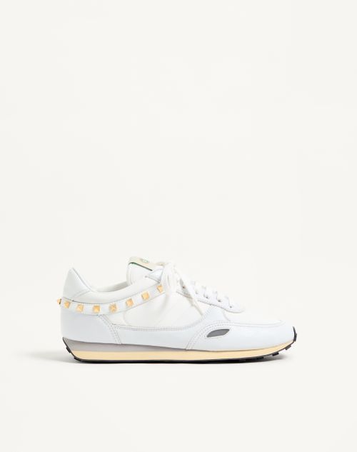 Tênis com tachas em couro e nylon.