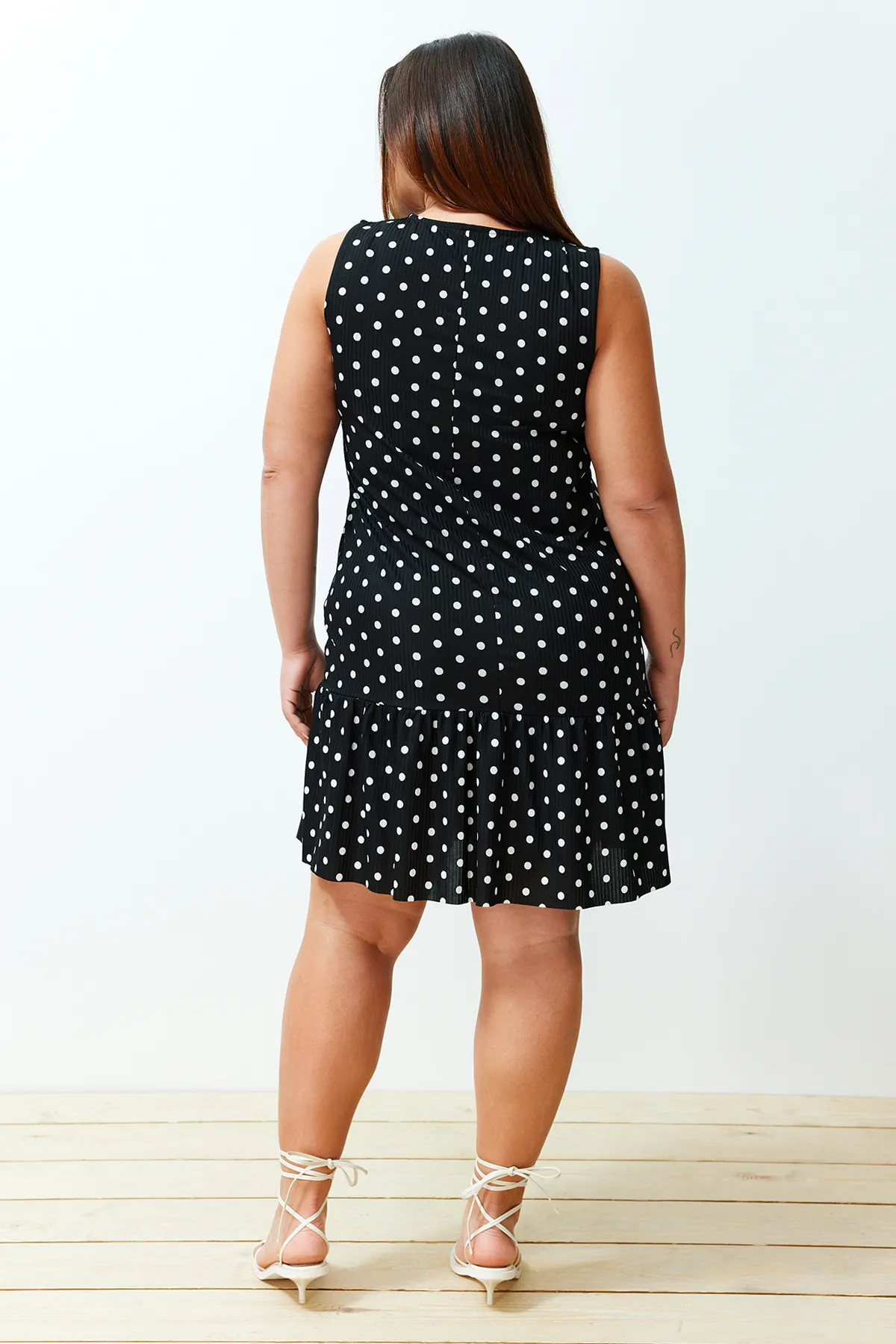 Trendyol Curve  Schwarzes, gepunktetes, ärmelloses, gerade geschnittenes Mini-Stretch-Strickkleid mit Volants TBSSS24AH00131