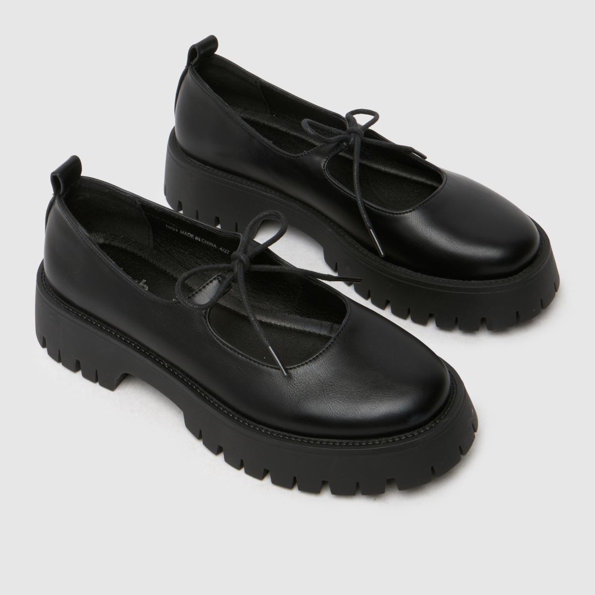 Schuh Liya – Svarta platta skor med fluga och Mary Jane-motiv