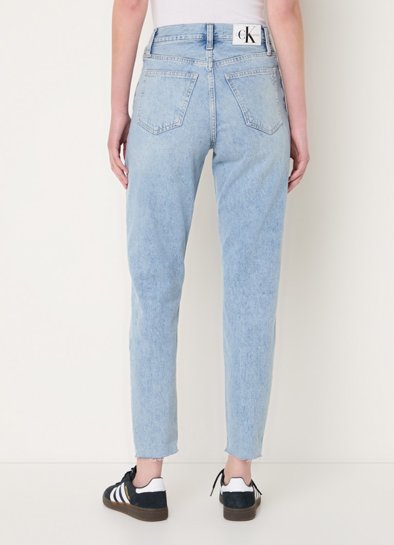 Calvin Klein high-waist mom jeans with a light wash and destroyed finish