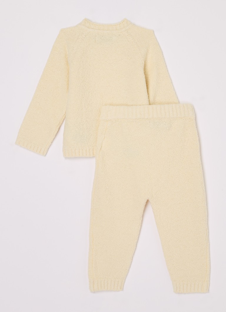 Un costum din două piese de la Calvin Klein, format dintr-un pulover și pantaloni, confecționați din material fin tricotat.
