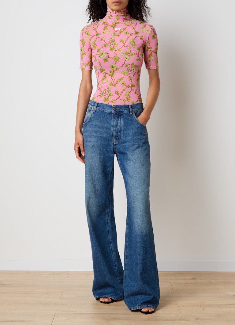 Bluză semitransparentă, de culoare crem, cu guler înalt și imprimeu floral.