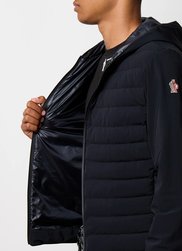 Jachetă matlasată Moncler cu glugă și buzunare cu fermoar.