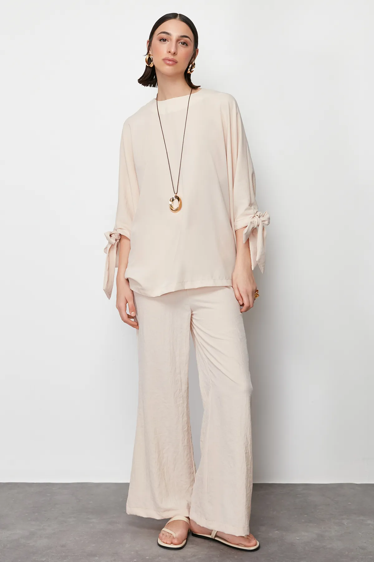 Trendyol Modest  Beigefarbenes Set aus gewebter Aerobin-Tunika und Hose mit Fledermausärmeln TCTSS23US00043