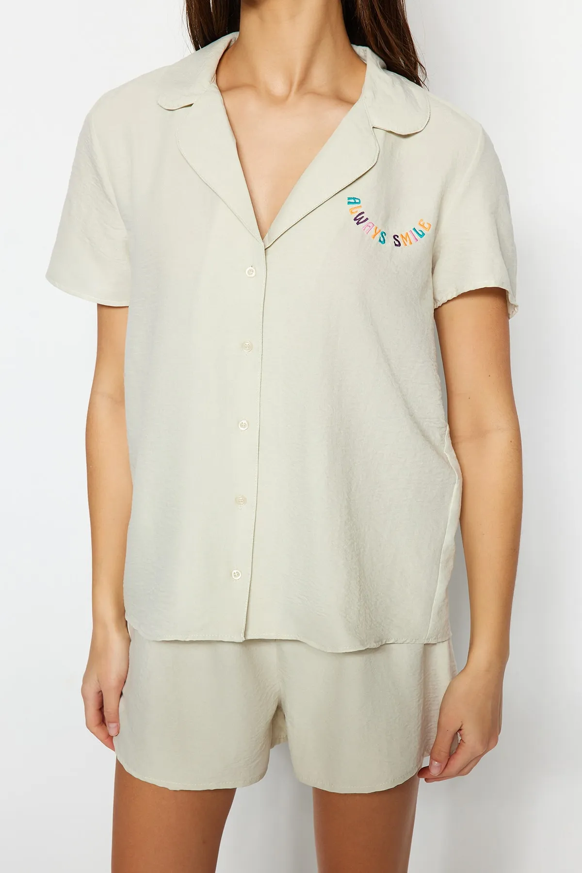 Trendyol Collection  Hellbeigefarbenes Pyjama-Set aus Hemd und Shorts mit aufgesticktem Slogan THMSS23PT00232