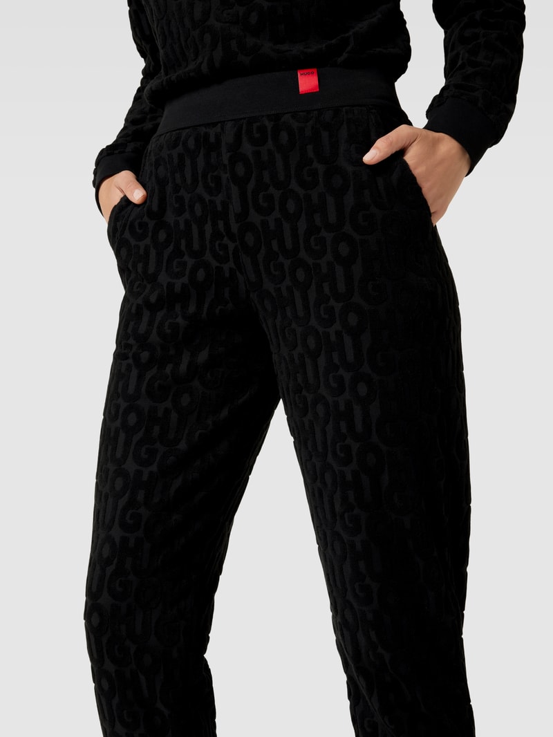 Jogpants mit Allover-Label-Muster aus Frottee Modell 'TERRY ME' in schwarz