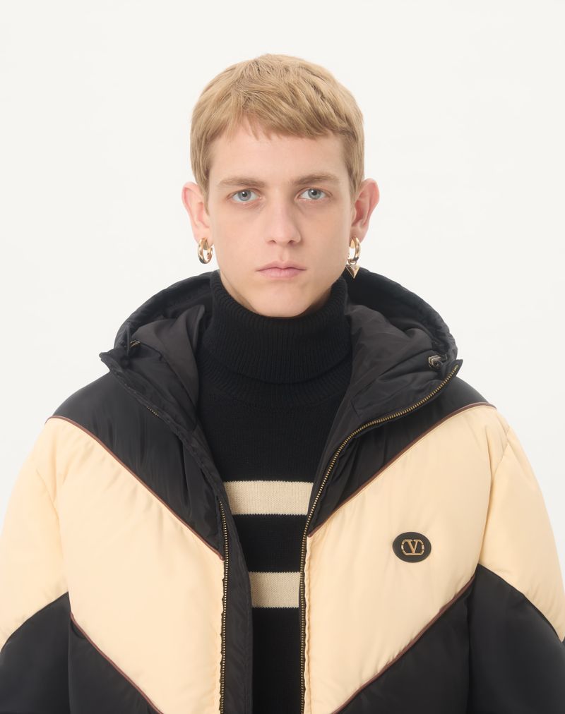 Jaqueta Valentino leve de nylon com capuz e enchimento de plumas, com detalhe em V e patch com o logo V.