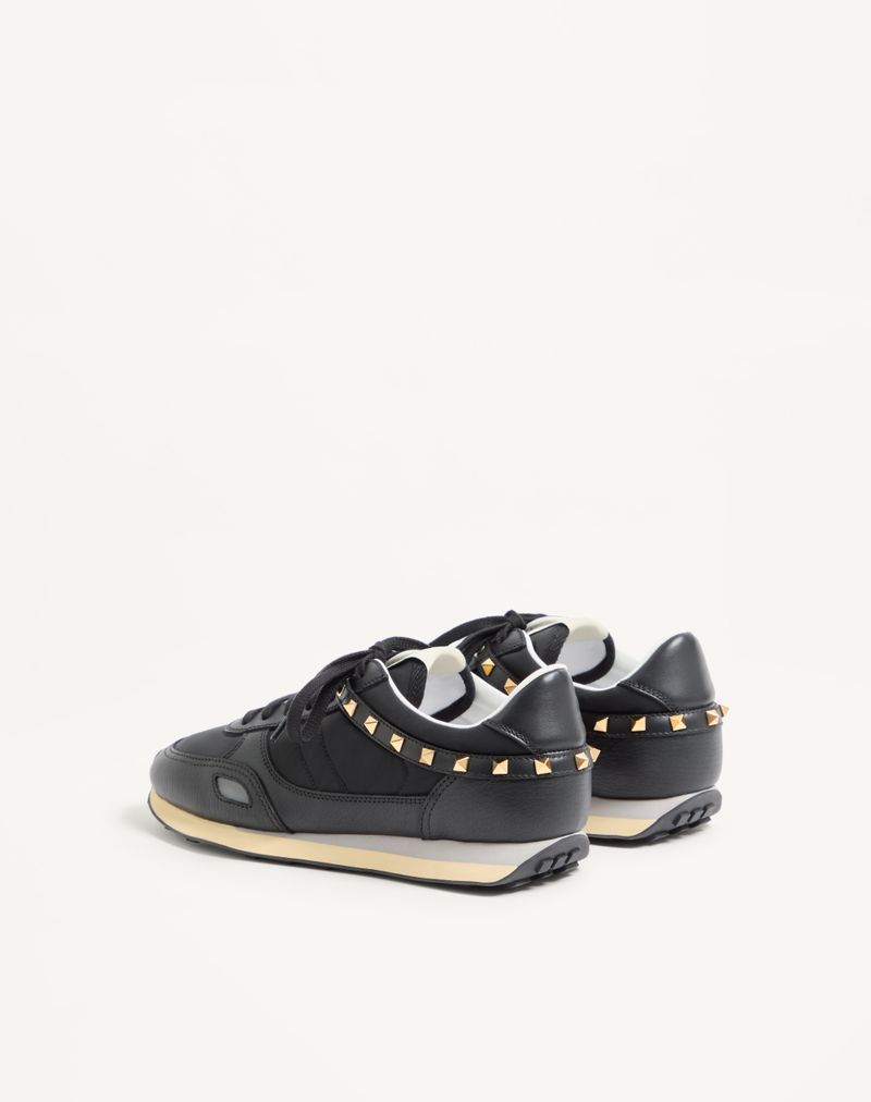 Tênis com tachas em couro e nylon.