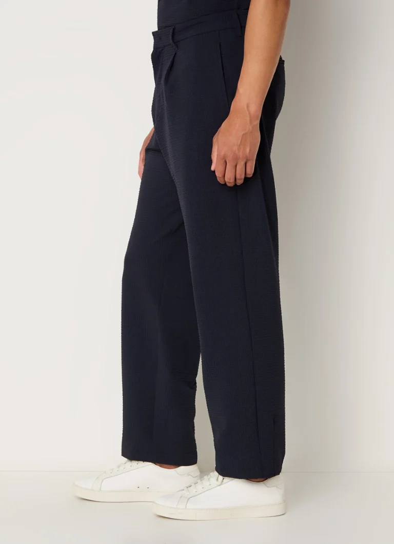 Pantaloni chino până la gleznă de la Emporio Armani, cu croială lejeră și mulată și buzunare laterale.