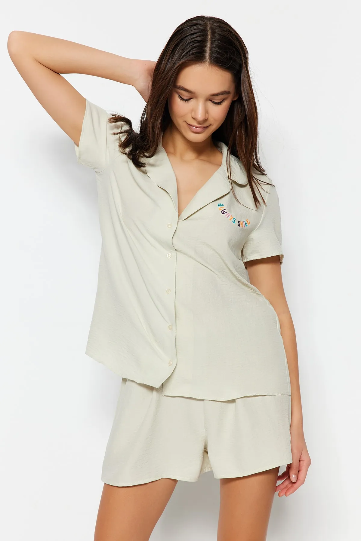 Trendyol Collection  Hellbeigefarbenes Pyjama-Set aus Hemd und Shorts mit aufgesticktem Slogan THMSS23PT00232