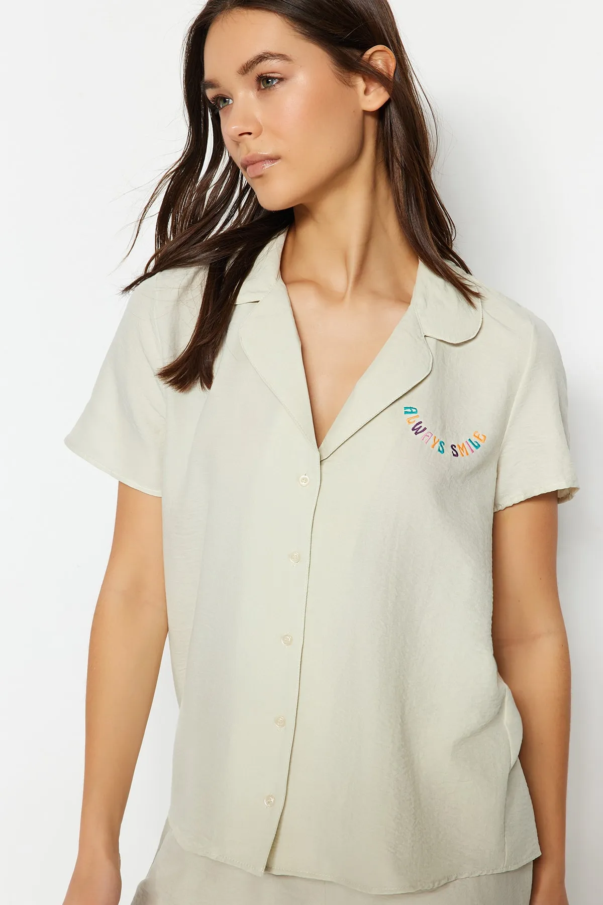 Trendyol Collection  Hellbeigefarbenes Pyjama-Set aus Hemd und Shorts mit aufgesticktem Slogan THMSS23PT00232