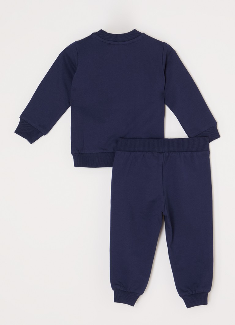 Costum din două piese Moschino, format dintr-un pulover și pantaloni de trening.